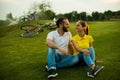 Young beautiful couple sitting on grass in the park. Royalty Free Stock Photo