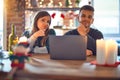 Young beautiful couple sitting using laptop around christmas decoration at home looking confident at the camera with smile with Royalty Free Stock Photo
