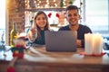 Young beautiful couple sitting using laptop around christmas decoration at home showing and pointing up with finger number one Royalty Free Stock Photo