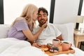 Young beautiful couple smiling happy having breakfast on the bed at home Royalty Free Stock Photo