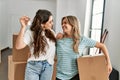 Young beautiful couple smiling happy holding cardboard box and key of new home Royalty Free Stock Photo