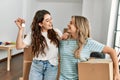 Young beautiful couple smiling happy holding cardboard box and key of new home Royalty Free Stock Photo