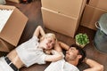 Young beautiful couple smiling happy relaxing with hands on head lying on the floor at new home Royalty Free Stock Photo