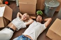Young beautiful couple smiling happy relaxing with hands on head lying on the floor at new home Royalty Free Stock Photo