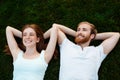 Young beautiful couple smiling, lying on grass in park. Shot from above. Royalty Free Stock Photo
