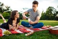 Young beautiful couple smiling, resting on picnic in park. Royalty Free Stock Photo