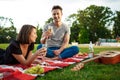 Young beautiful couple smiling, resting on picnic in park. Royalty Free Stock Photo