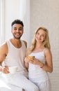 Young Beautiful Couple Stand Near Big Window, Drink Morning Coffee Cup, Happy Smile Hispanic Man Woman Royalty Free Stock Photo