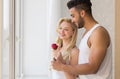 Young Beautiful Couple Stand Near Big Window, Hispanic Man Give Woman Red Rose Royalty Free Stock Photo