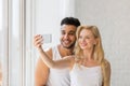 Young Beautiful Couple Stand Window, Taking Selfie Photo On Cell Smart Phone