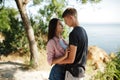 Young beautiful couple standing dreamily looking on each other over sea view