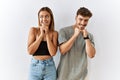 Young beautiful couple standing together over isolated background laughing nervous and excited with hands on chin looking to the Royalty Free Stock Photo