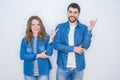 Young beautiful couple standing together over white isolated background with a big smile on face, pointing with hand and finger to Royalty Free Stock Photo