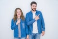 Young beautiful couple standing together over white isolated background cheerful with a smile of face pointing with hand and Royalty Free Stock Photo