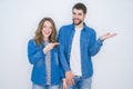 Young beautiful couple standing together over white isolated background smiling cheerful presenting and pointing with palm of hand Royalty Free Stock Photo