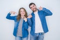 Young beautiful couple standing together over white isolated background smiling cheerful showing and pointing with fingers teeth Royalty Free Stock Photo