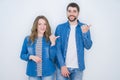 Young beautiful couple standing together over white isolated background smiling with happy face looking and pointing to the side Royalty Free Stock Photo