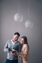 Young beautiful couple of students are studying books standing on the background of a gray wall Royalty Free Stock Photo