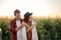 Young beautiful couple take a break during trip, stopped near cornfield, enjoy