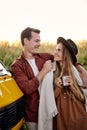 Young beautiful couple take a break during trip, stopped van near cornfield, enjoy