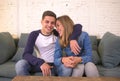 Young beautiful couple teenagers or 20s romantic girlfriend and boyfriend in love smiling happy cuddling on home sofa couch in rom Royalty Free Stock Photo