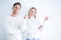 Young beautiful couple wearing casual t-shirt standing over isolated white background with a big smile on face, pointing with hand Royalty Free Stock Photo