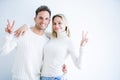 Young beautiful couple wearing casual t-shirt standing over isolated white background smiling with happy face winking at the Royalty Free Stock Photo