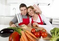 Young beautiful couple working at home kitchen preparing vegetable salad together smiling happy Royalty Free Stock Photo