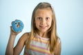 Young beautiful happy and excited blond girl 8 or 9 years old holding donut desert on her hand looking spastic and cheerful in sug