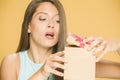 Young beautiful curious woman opening a present box