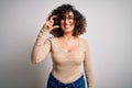 Young beautiful curly arab woman wearing casual t-shirt and glasses over white background smiling and confident gesturing with Royalty Free Stock Photo