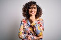 Young beautiful curly arab woman wearing floral colorful shirt standing over white background looking confident at the camera Royalty Free Stock Photo