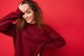 Young beautiful curly brunette woman with sincere emotions poising isolated on background wall with copy space wearing Royalty Free Stock Photo