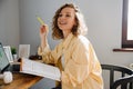 Young beautiful curly smiling woman holding textbook and pencil Royalty Free Stock Photo