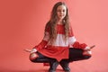 Young beautiful cute girl dancing on red background, modern slim hip-hop style teenage girl jumping Royalty Free Stock Photo