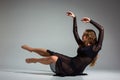 Young beautiful dancer in black dress posing on a dark gray studio background Royalty Free Stock Photo