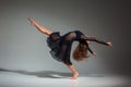 Young beautiful dancer in black dress posing on a dark gray studio background Royalty Free Stock Photo