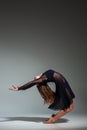 Young beautiful dancer in black dress posing on a dark gray studio background Royalty Free Stock Photo