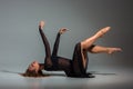 Young beautiful dancer in black dress posing on a dark gray studio background Royalty Free Stock Photo