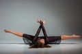 Young beautiful dancer in black dress posing on a dark gray studio background Royalty Free Stock Photo