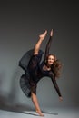 Young beautiful dancer in black dress posing on a dark gray studio background Royalty Free Stock Photo