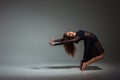 Young beautiful dancer in black dress posing on a dark gray studio background Royalty Free Stock Photo