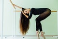 Young beautiful dancer posing in studio wit Ballet bar on tiptoe. Modern brunette. Royalty Free Stock Photo
