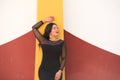 Young, beautiful, dark-haired woman is dressed elegantly in a black dress with transparencies. The girl leans against the wall Royalty Free Stock Photo