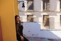 Young, beautiful, dark-haired woman is dressed elegantly in a black dress with transparencies. The girl leans against the wall Royalty Free Stock Photo