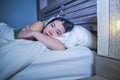 Young beautiful depressed and sad Asian Chinese woman having insomnia lying in bed at night sleepless suffering anxiety stress and Royalty Free Stock Photo