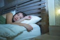 Young beautiful depressed and sad Asian Chinese woman having insomnia lying in bed at night sleepless suffering anxiety stress and Royalty Free Stock Photo