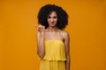 Young beautiful disgusted curly woman pointing aside with thumb finger Royalty Free Stock Photo