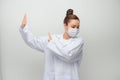 Young beautiful doctor woman wearing coat afraid and terrified with fear expression stop gesture with hands, shouting in shock