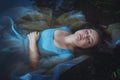 Young beautiful drowned woman in blue dress lying in the river Royalty Free Stock Photo